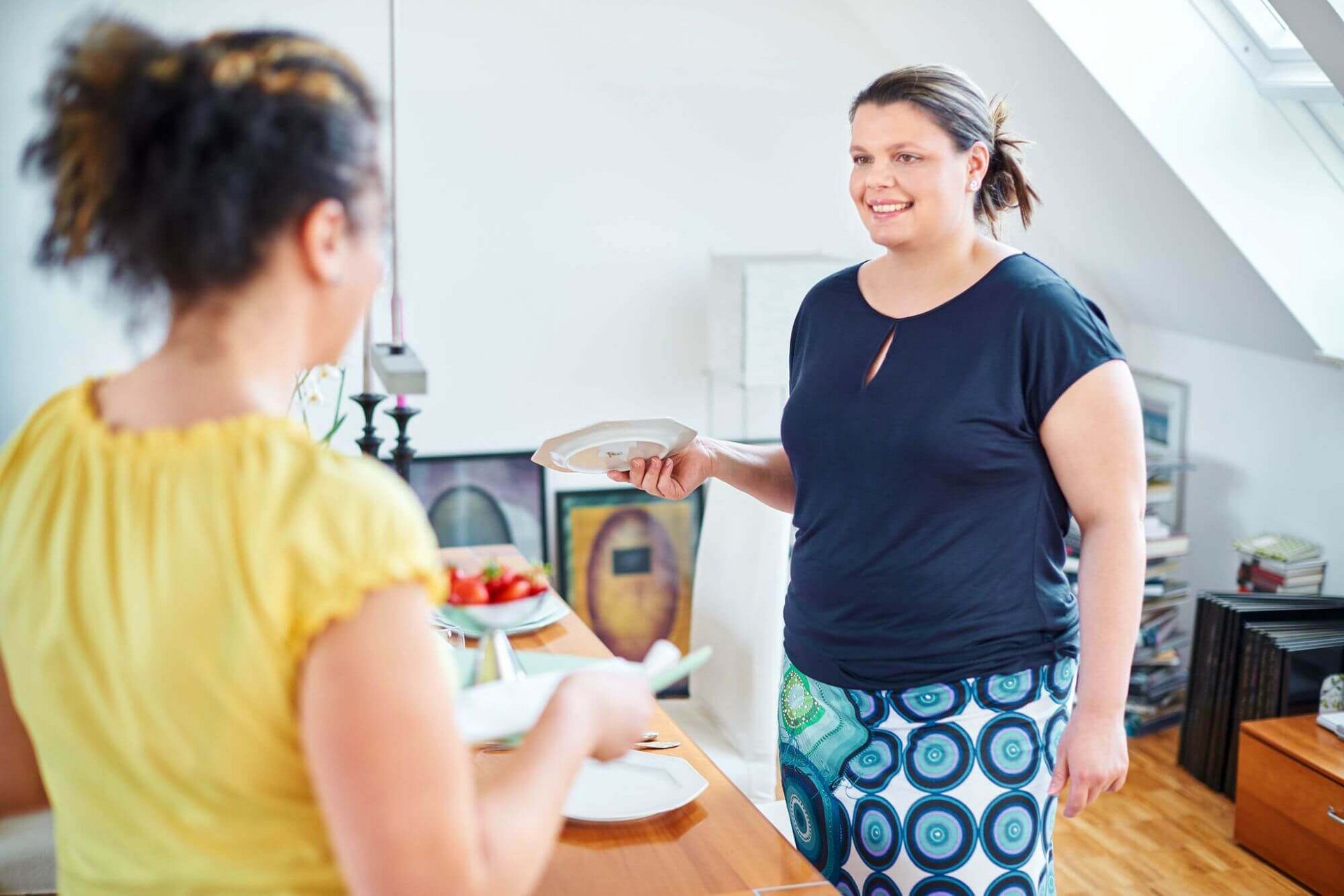 Zwei Frauen stehen in einer Küche und kochen zusammen. Eine gesunde und ausgewogene Ernährung ist sehr hilfreich bei der Behandlung von Lipolymphödemen.